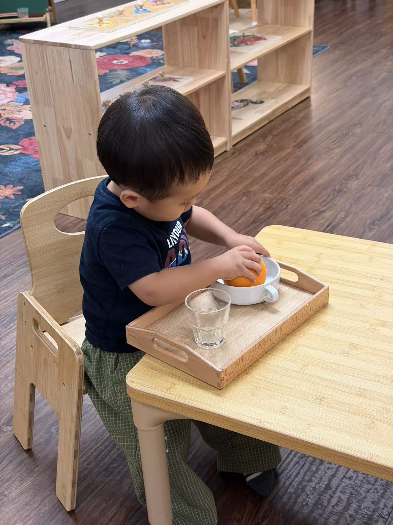 a child using a hand juicer to make orange juice