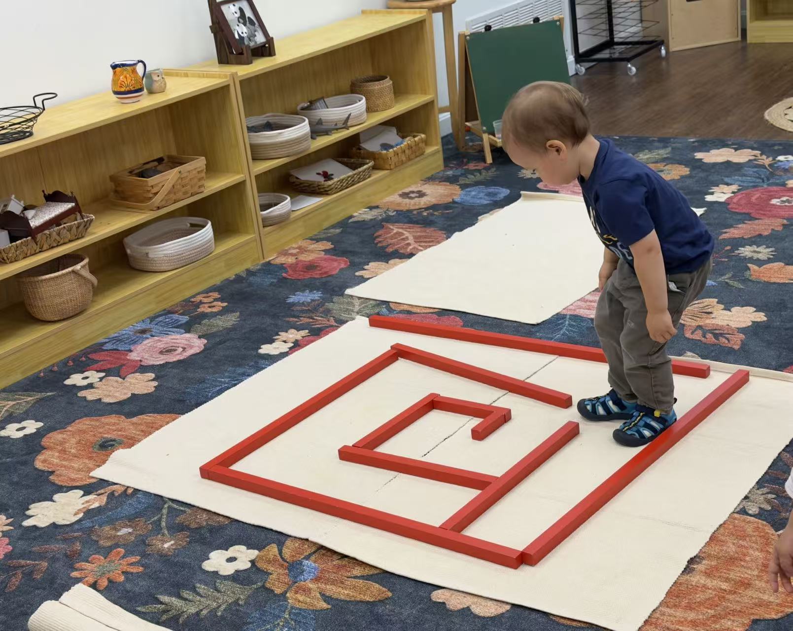 a child walking along a maze path made of red rods